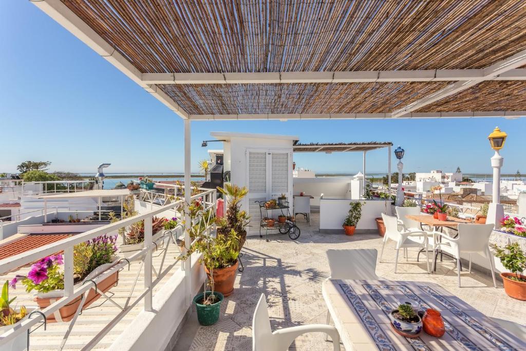 奥良AL - 阿罗亚蒙托比库阿本地旅馆的阳台配有桌椅,享有海景。