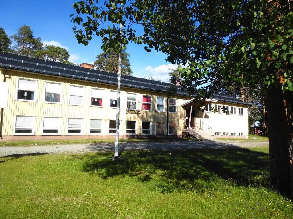 Väster GafseleGafsele Lappland Hostel的前方有树的白色大建筑
