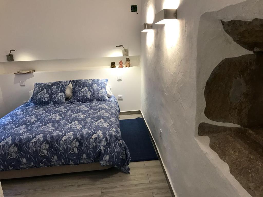 托马尔A Gosto的一间卧室配有一张带蓝色棉被的床