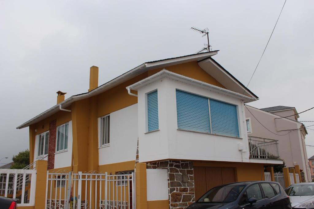 利洛Casa do Roxo de Rinlo Nº REGISTRO VUT-LU-00706的黄色和白色的房子,有蓝色百叶窗