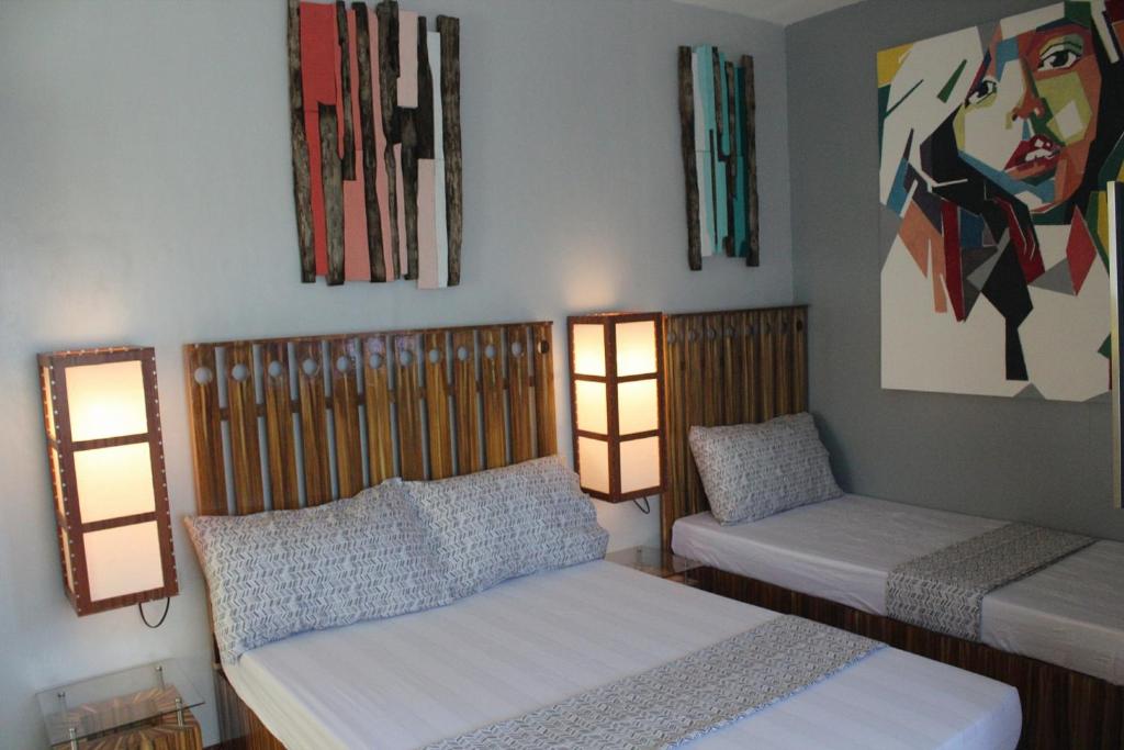 塔比拉兰戈麦斯公寓的一间卧室配有两张床,墙上有两盏灯