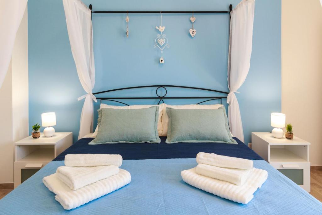 陶尔米纳Lumia e Zagara的一间卧室配有蓝色的床和毛巾