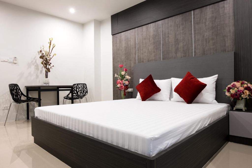 曼谷DB Plus 5的一间卧室配有一张带红色枕头的大床
