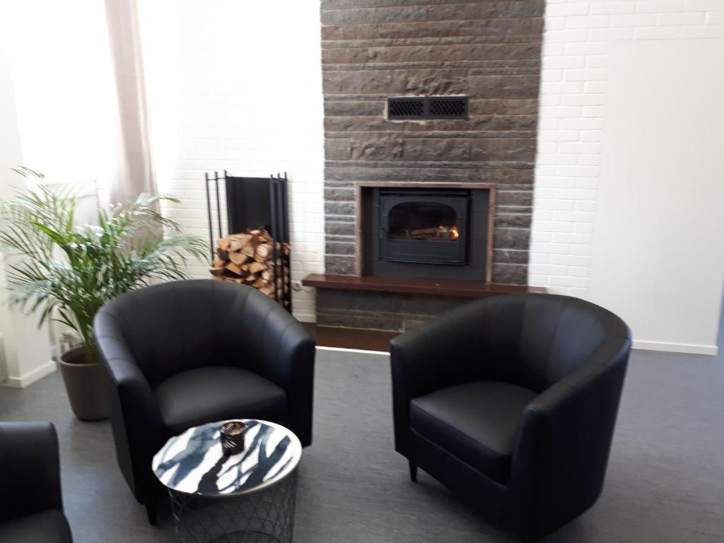 卡利克斯STF Kalix Vandrarhem的客厅配有两把椅子和壁炉