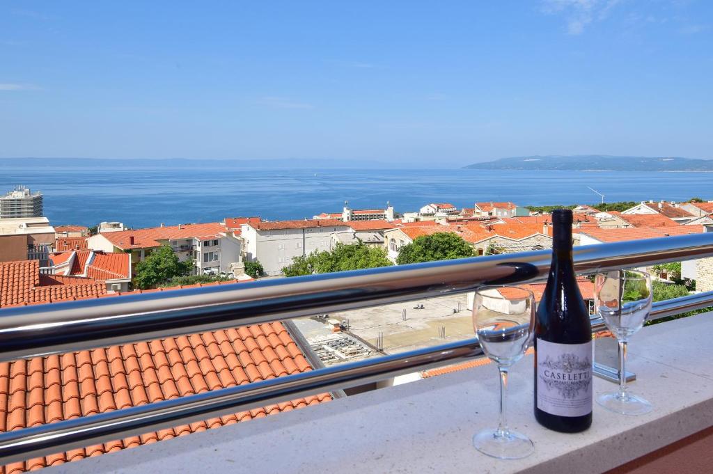 马卡尔斯卡Apartments Evelin的阳台上的一瓶葡萄酒和两杯酒