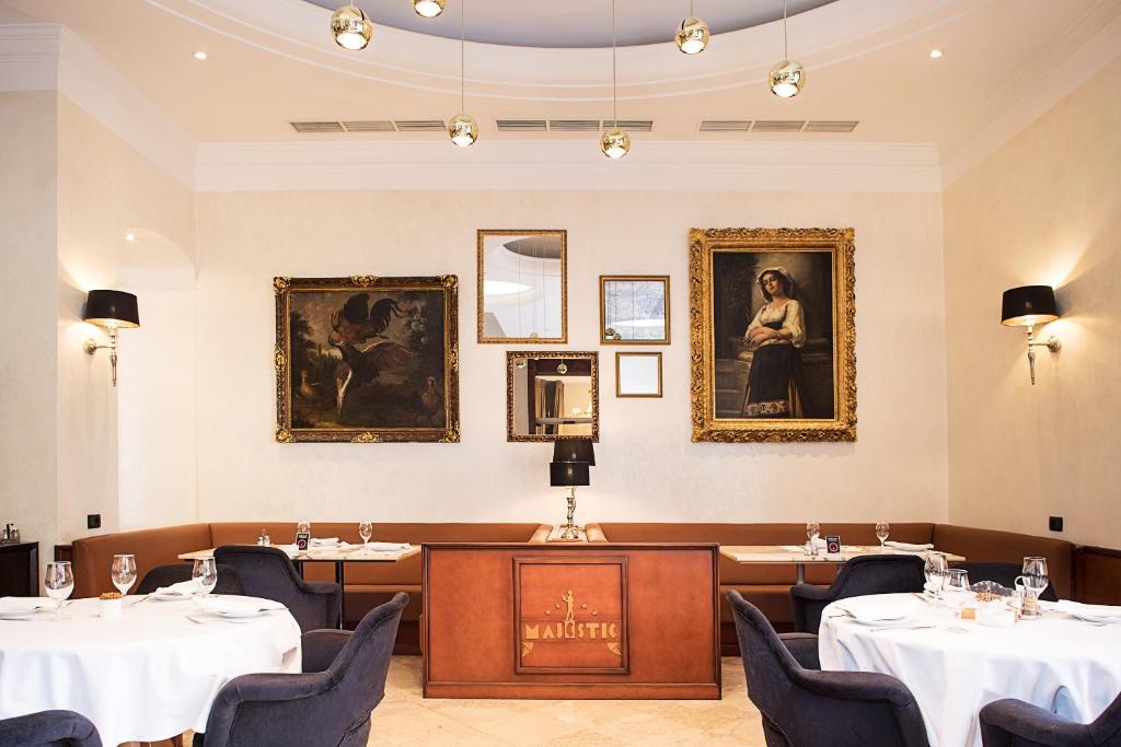 贝尔格莱德玛吉斯迪克酒店的用餐室配有桌椅和墙上的画像