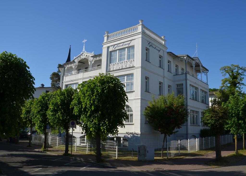 宾茨Strandvilla Glückauf的前面有树木的白色建筑