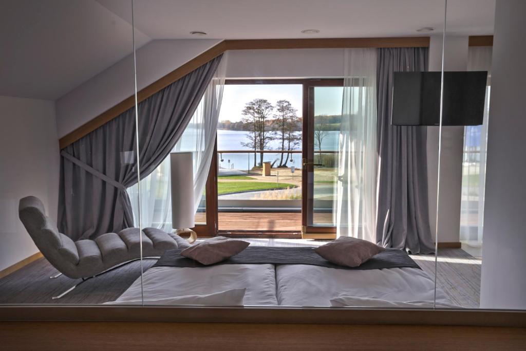 奥尔什丁Hotel Marina Club的一间卧室配有一张带大玻璃窗的床