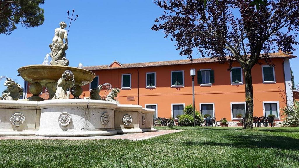 拉蒂纳Il Casale Corte Rossa的建筑物前草上的喷泉