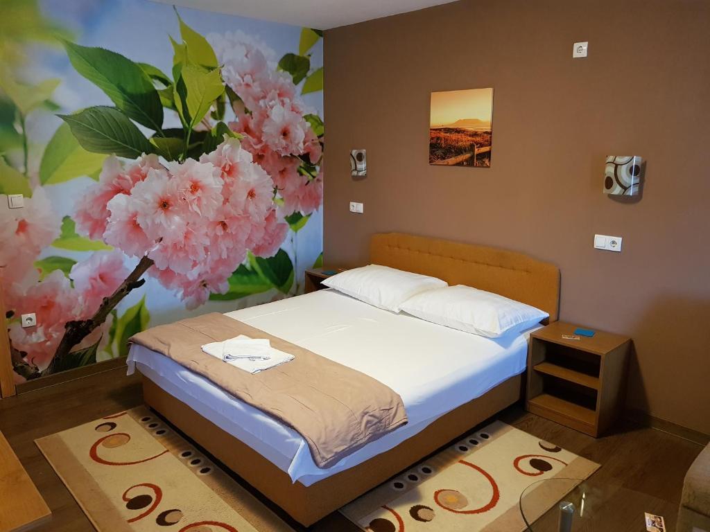普里耶多尔Guest House Babilon的一间卧室配有床和花卉壁画