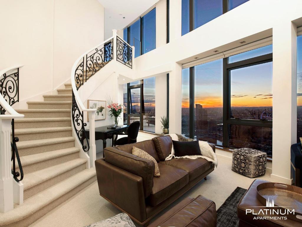 墨尔本Platinum Luxury Stays at The Victoria Rooftop Penthouse的带沙发和楼梯的客厅