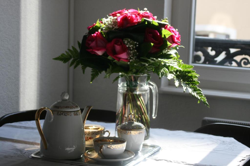 斯特拉斯堡Appartement 3 pièces, Krutenau, Parking privé的花瓶坐在桌子上,带杯子