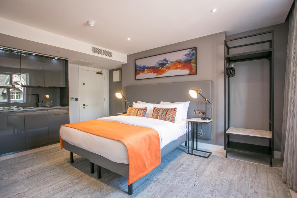 都柏林Grafton Street Studios by City Break Apartments的一间卧室配有一张带橙色毯子的大床