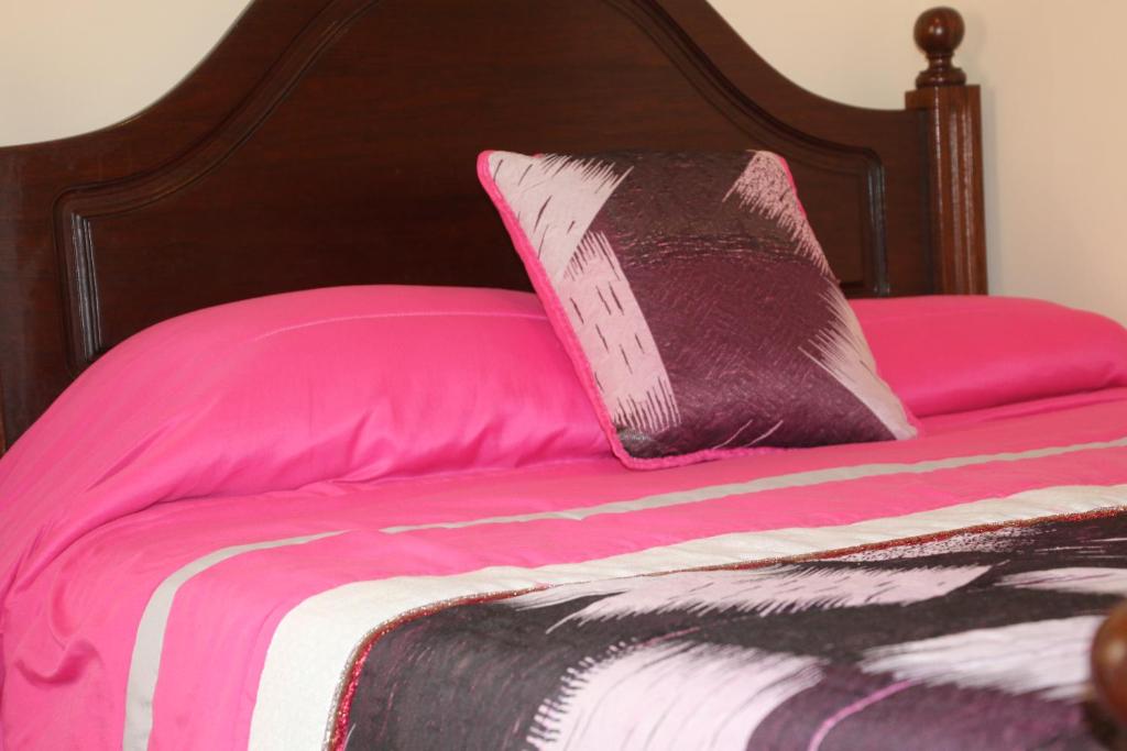 纳扎雷Salvador Beach House II的粉红色的床,上面有黑色和粉红色的枕头