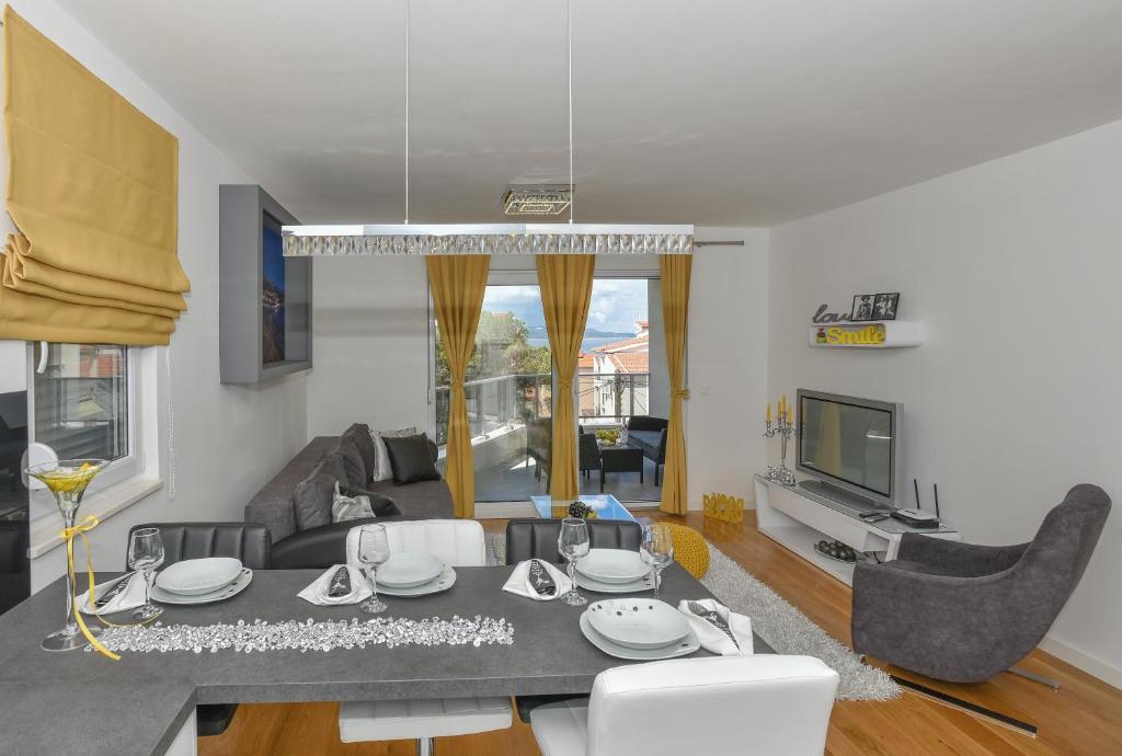 马卡尔斯卡Apartment Đaninovica I的客厅配有餐桌和电视