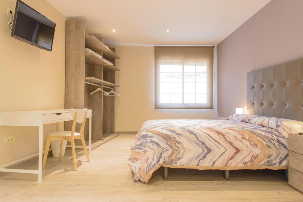 塔拉戈纳Vive Tarragona的一间卧室配有一张床、一张桌子和一张桌子