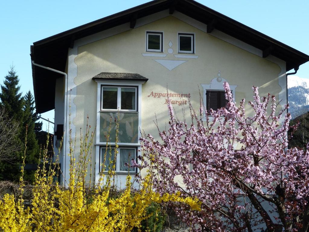维皮泰诺Appartements Margit的前面有一棵开花的树的房子