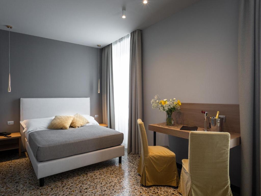 热那亚HNN Luxury Suites的一间卧室配有一张床、一张桌子和一张桌子