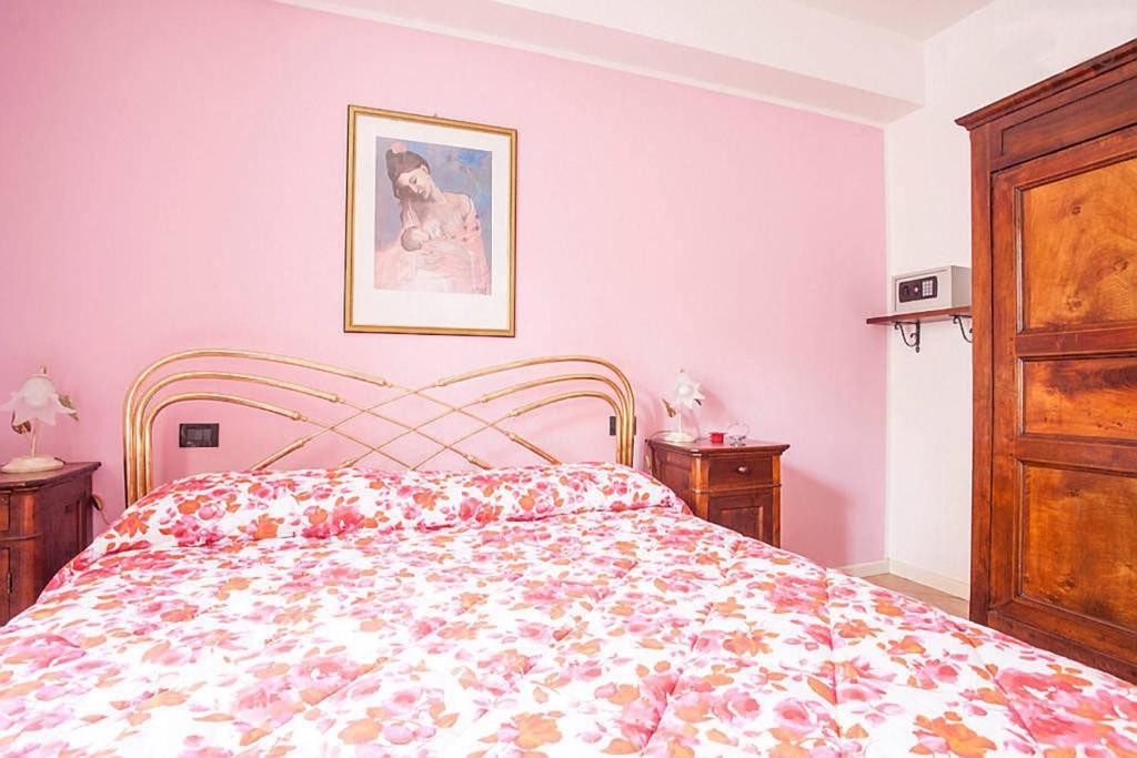 克雷莫纳Residenza "Il Torrazzo"的一间卧室配有一张带花卉床罩的床