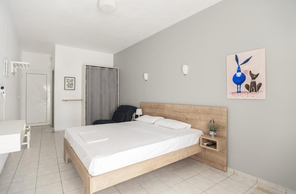 波利克罗诺Afkos Apartments的一间卧室配有一张床、一张桌子和一把椅子