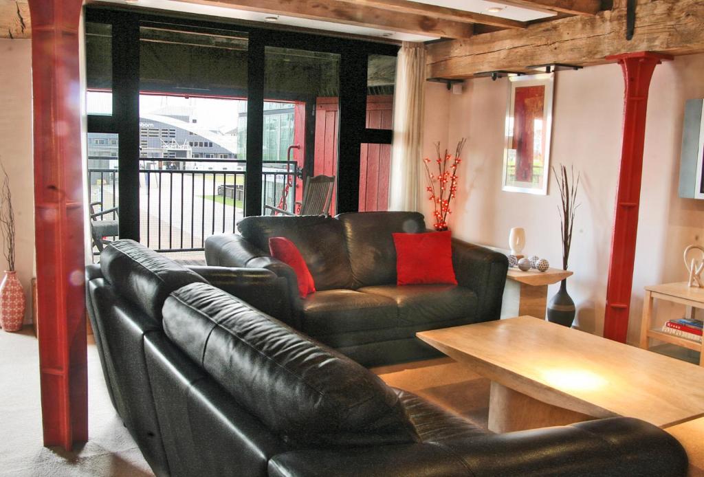 伦敦K仓库3号公寓的客厅配有真皮沙发和桌子