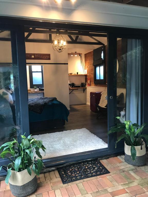 旺阿雷Studio9的一间设有床铺的房间和一个带植物的玻璃门
