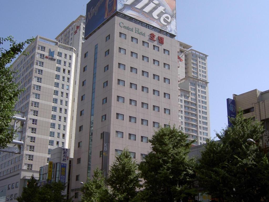 釜山釜山中央大酒店的一座高大的白色建筑,上面有标志
