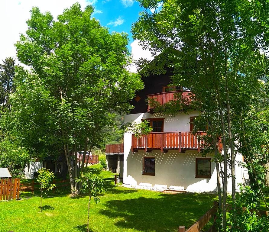 弗拉塔赫Appartement Jana的白色的房子,设有红色的阳台和树木