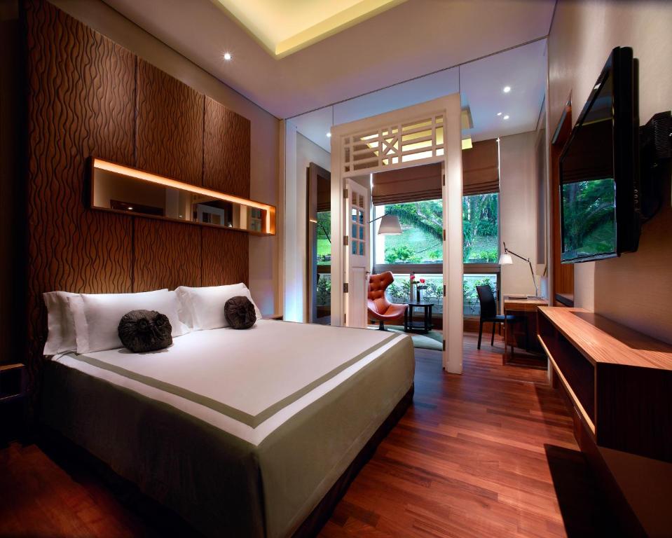 新加坡福康宁酒店的卧室配有一张白色大床和一张书桌