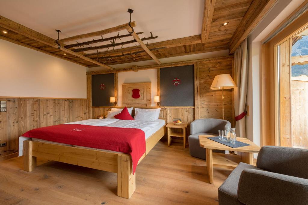 米滕瓦尔德Gröbl-Alm的酒店客房配有床、沙发和桌子。