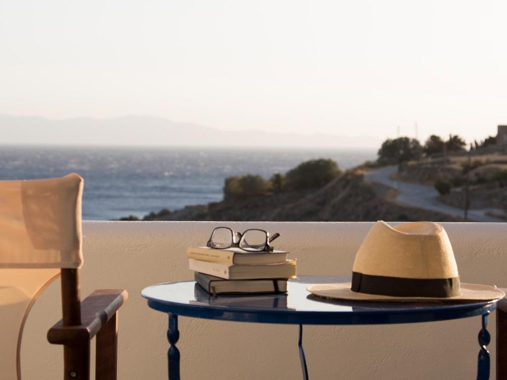 圣罗曼诺斯Meltemi Tinos的一张桌子,上面有书,帽子和眼镜