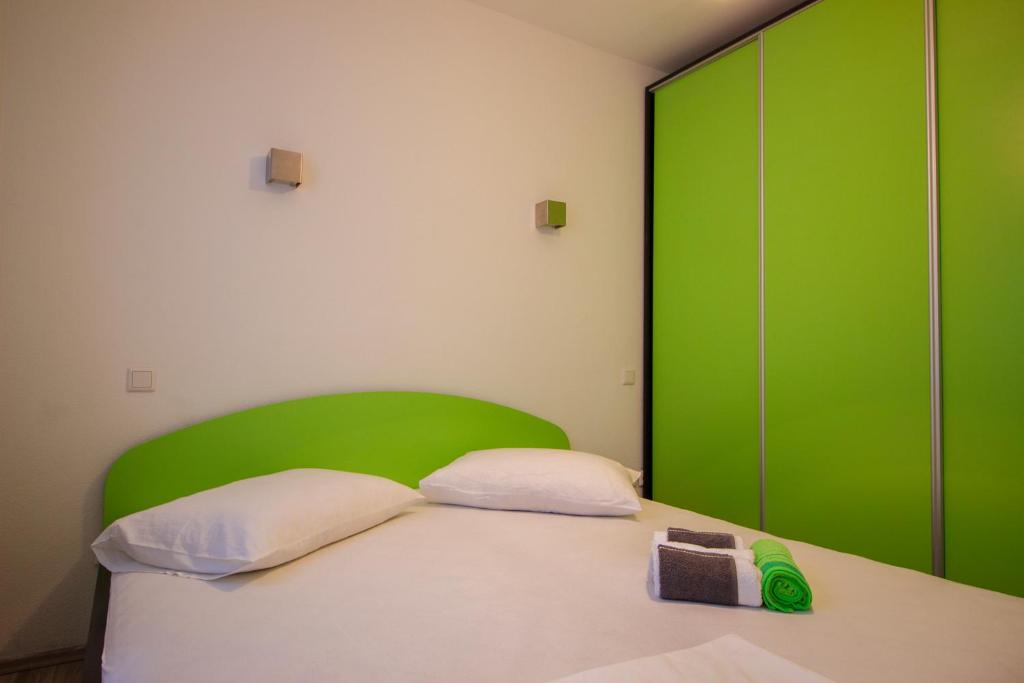 杜埃Apartments Hajdi的一间卧室配有绿色床头板和一张床