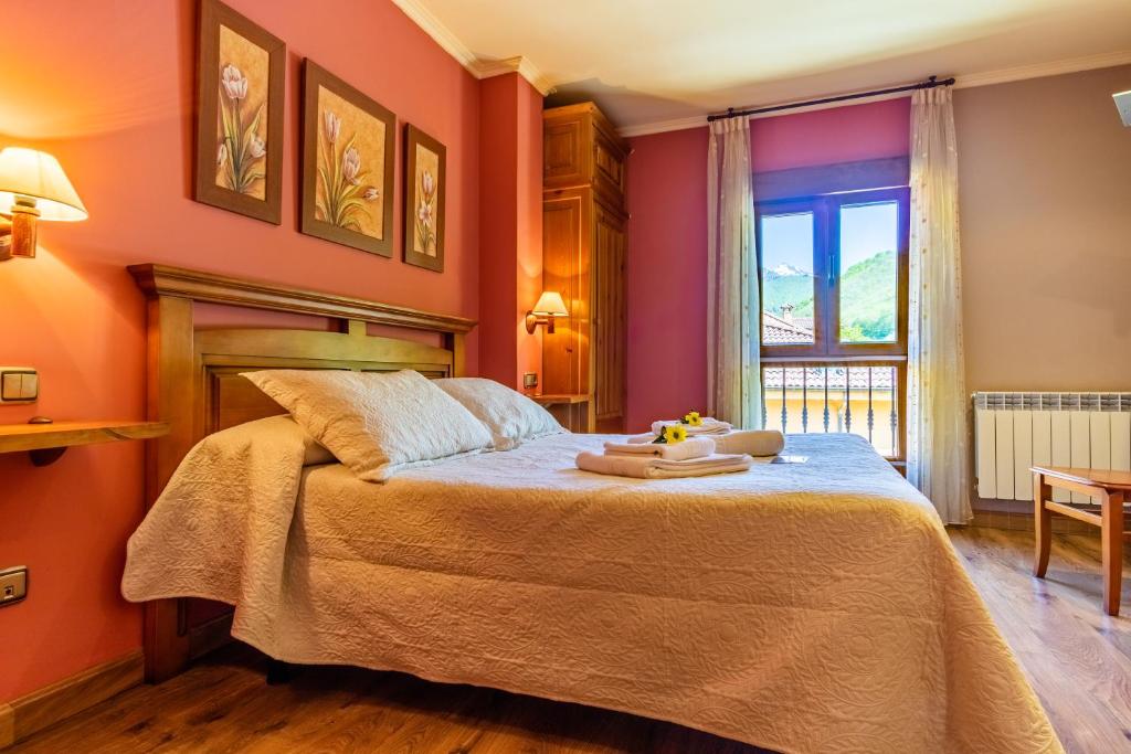 费莱乔萨Hotel Peña Pandos的一间卧室配有一张带橙色墙壁和窗户的床