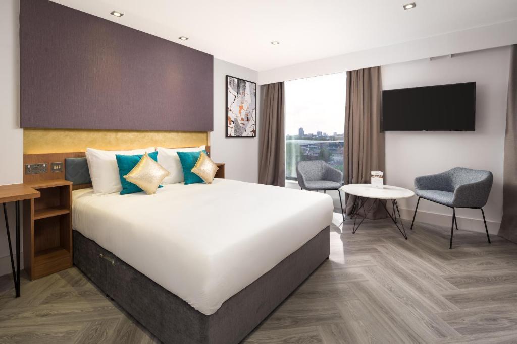 伦敦伦敦斯特拉福德隆姆茨公寓式酒店的酒店客房设有一张大床和一张书桌。