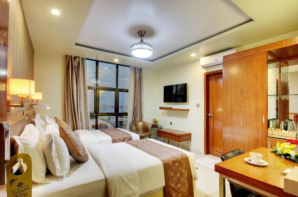 马累尤尼马格兰德酒店的酒店客房设有两张床和电视。