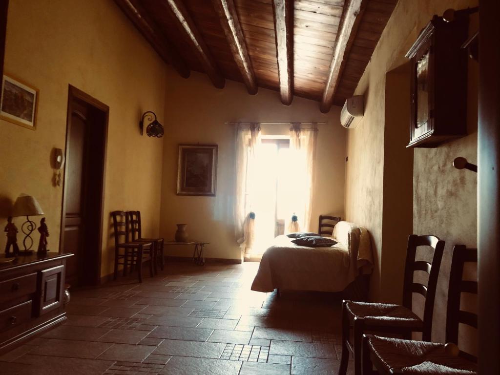 CollesanoAgriturismo Ilardo的一间卧室配有一张床、一个窗口和椅子