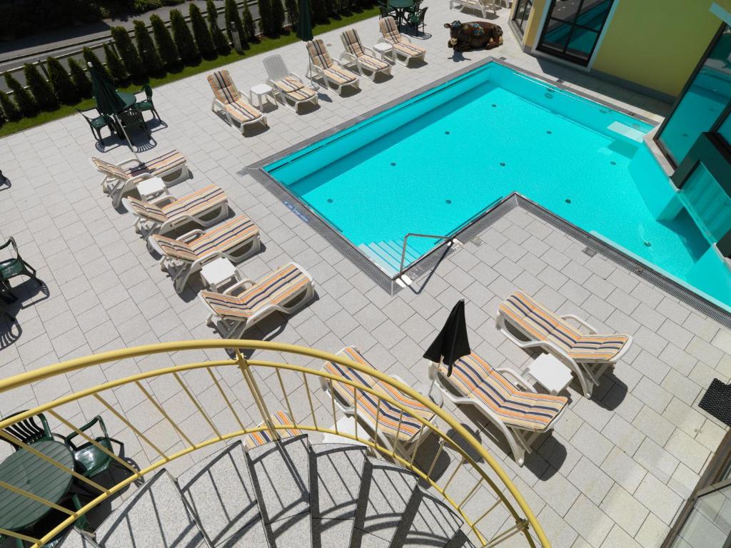 巴德小基希海姆高山温泉公寓酒店的享有带躺椅和滑梯的游泳池的上方景色