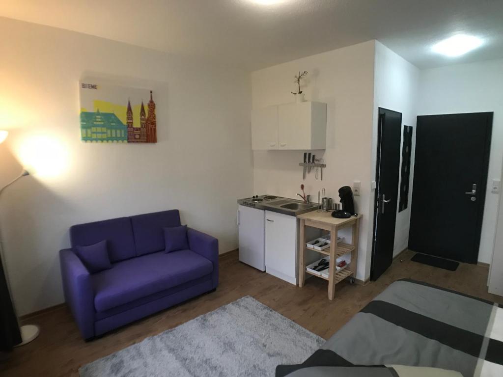 不莱梅Living @ Klassvilla Weserwehr No. 3的一间带紫色沙发的客厅和一间厨房
