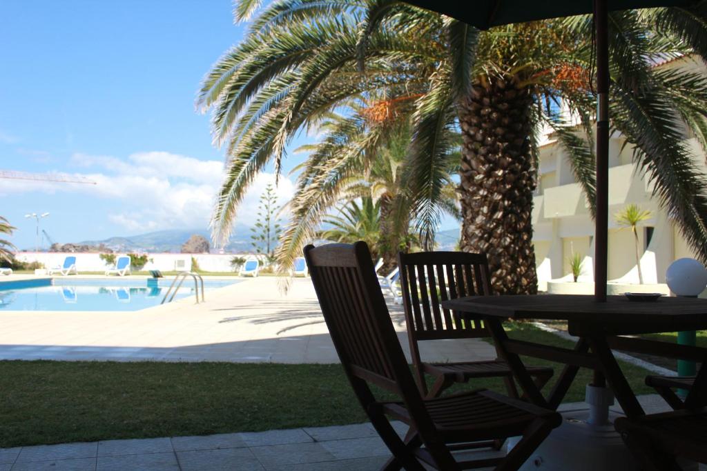 马达莱纳卡拉维拉斯酒店的游泳池旁棕榈树下的桌椅