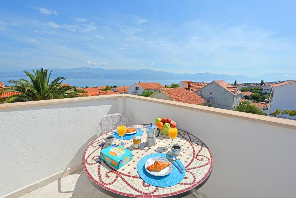 苏佩塔尔Apartments Residence Sunce Supetar - cozy base to stay and explore island Brac的阳台上的桌子上摆放着食物和饮料