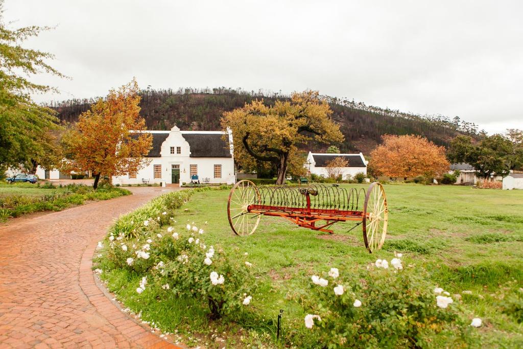 弗朗斯胡克巴斯普罗旺斯乡间别墅酒店的坐在房子前面的草上的一个红色长凳