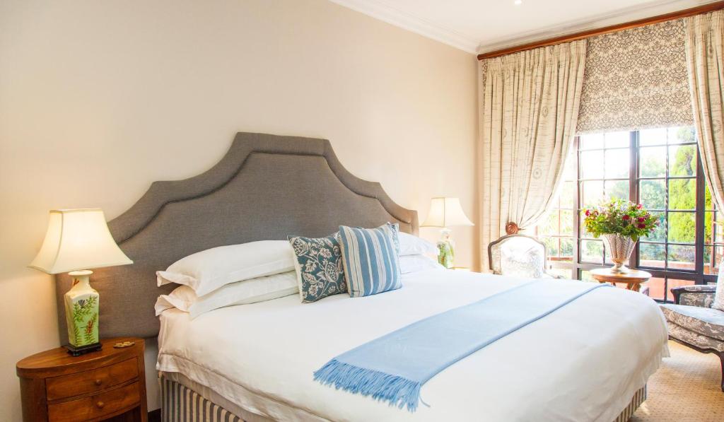 比勒陀利亚Ivory Manor Boutique Hotel的卧室设有一张白色大床和一扇窗户。