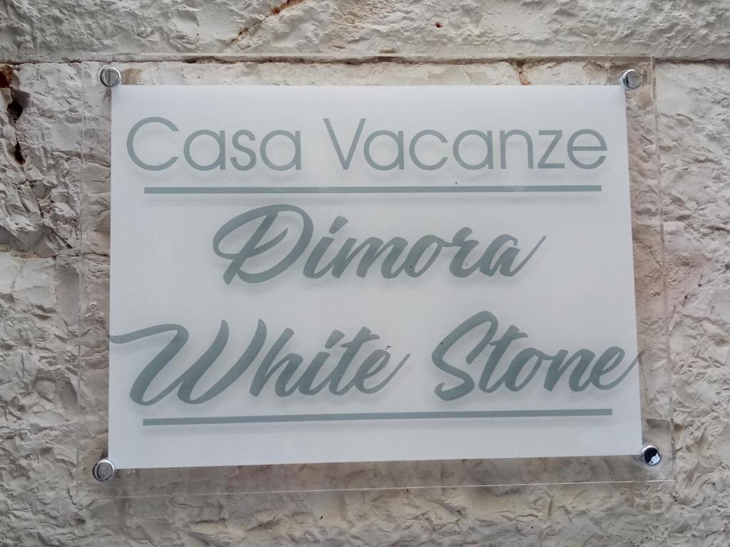 科拉托Dimora WhiteStone的石墙上白色商店的标志