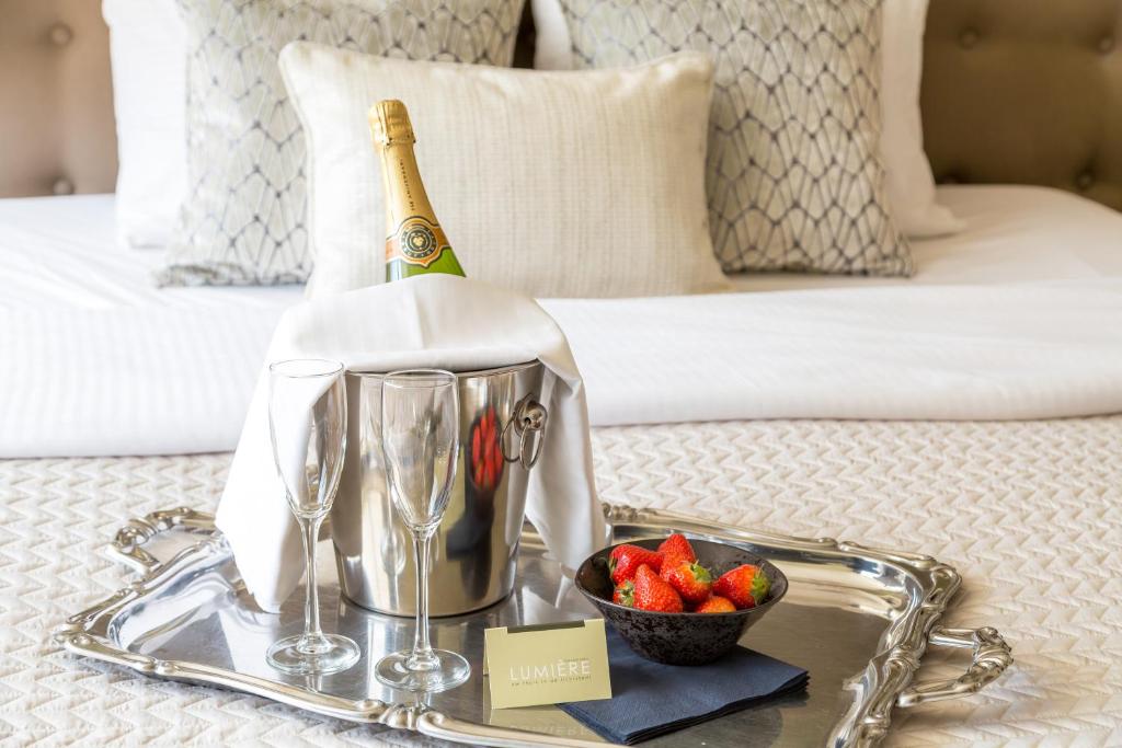 埃因霍温卢米埃尔精品酒店的托盘,内含一瓶香槟和一碗草莓