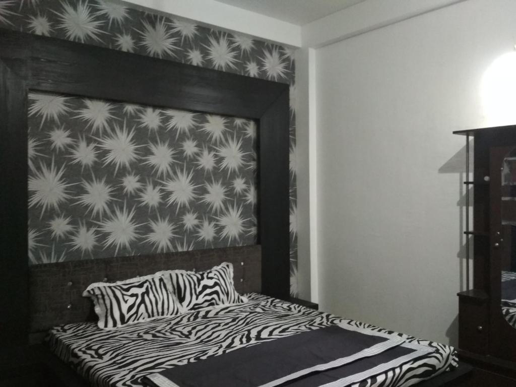 印多尔Ashta Lakshmi Tourist Home Stay的一间卧室配有一张带斑马打印床头板的床