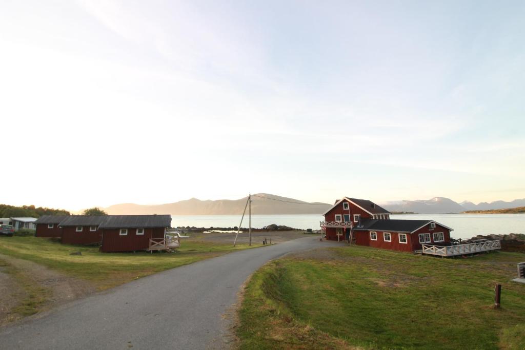 AlsvågToftenes Sjøhuscamping的通往村庄的道路,村庄里设有房屋和湖泊