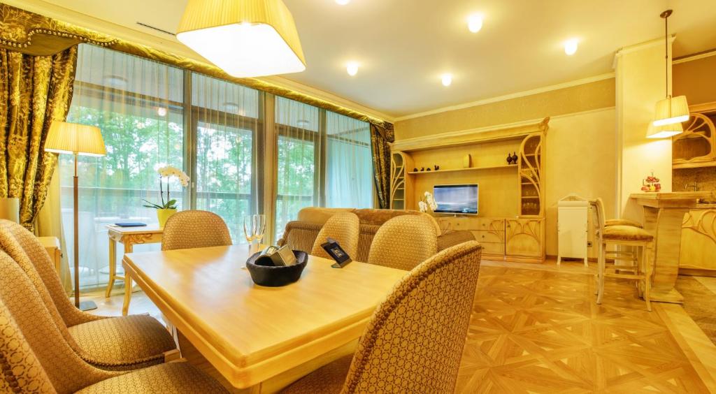 德鲁斯基宁凯立陶宛祖基亚SPA服务式公寓大酒店的用餐室以及带桌椅的起居室。