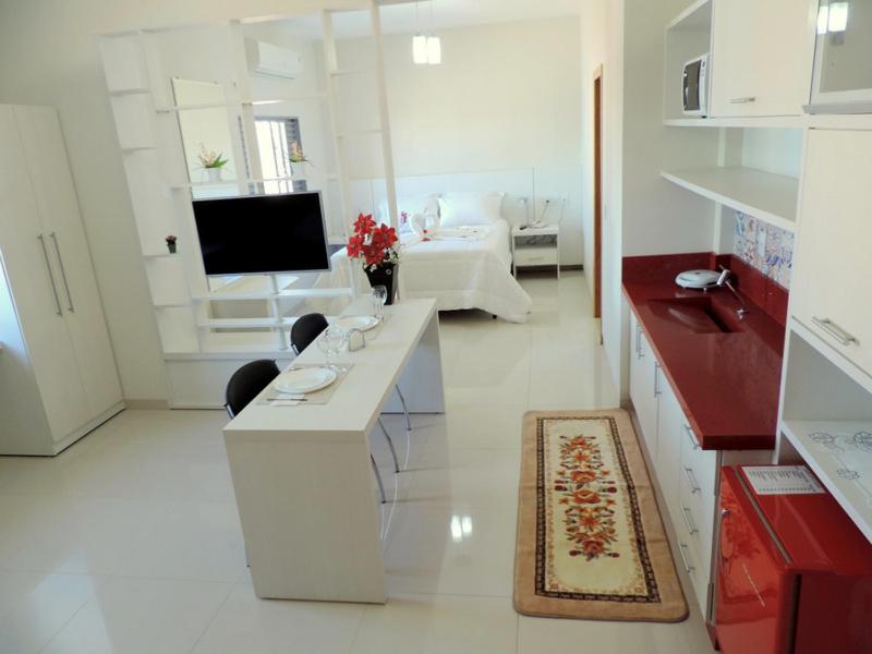 Campo VerdeHotel Pequeno Mundo 2的白色的客厅配有书桌和电视。