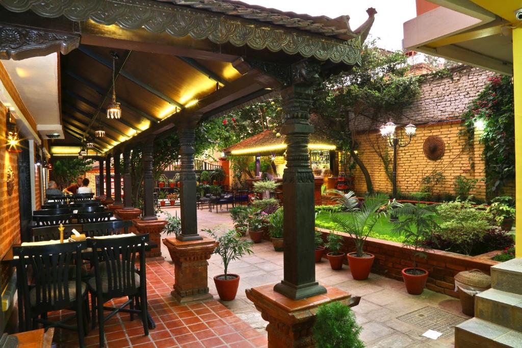 加德满都塔莱珠女精品酒店 的餐厅内带桌椅的庭院