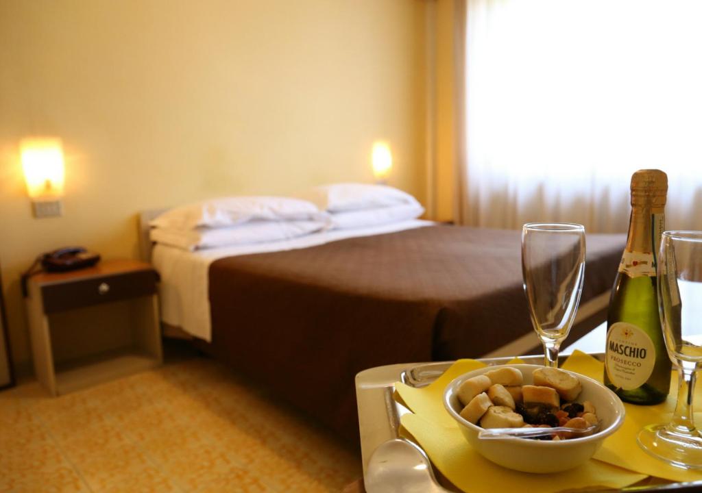 下诺切拉Hotel Sole的酒店客房,配有一张床和一张桌子,还有一碗食物